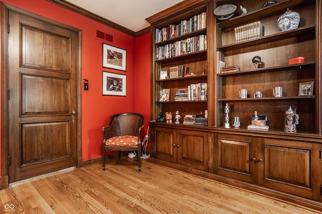 sitting room featuring ornamental molding and light hardwood / wood-style floors