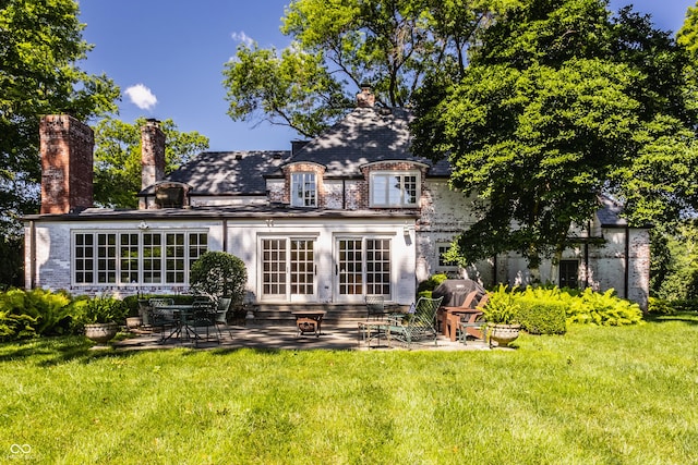 back of house with a lawn and a patio area