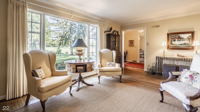 sitting room featuring crown molding and hardwood / wood-style floors