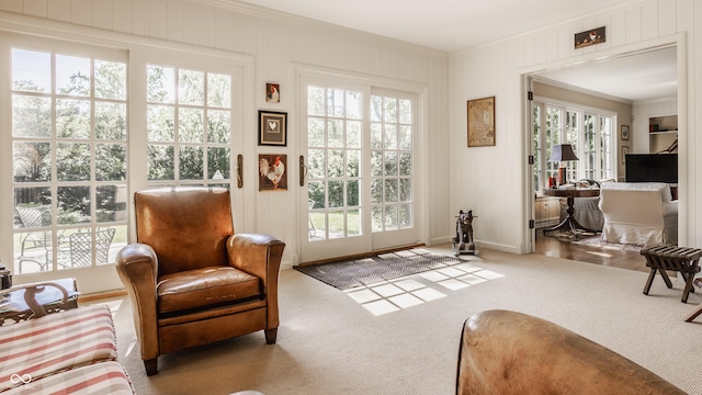 doorway featuring crown molding and light colored carpet