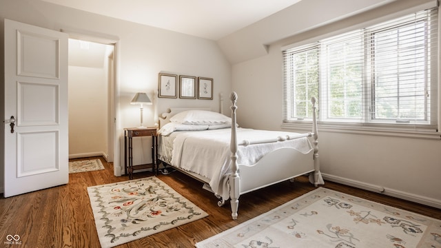 bedroom featuring lofted ceiling and dark hardwood / wood-style flooring