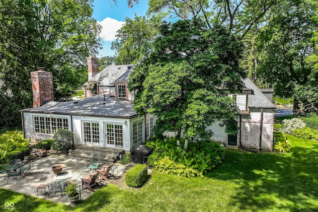 rear view of house featuring a patio, a yard, and french doors