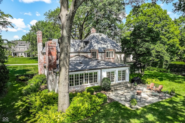 back of property with french doors, a yard, and a patio area