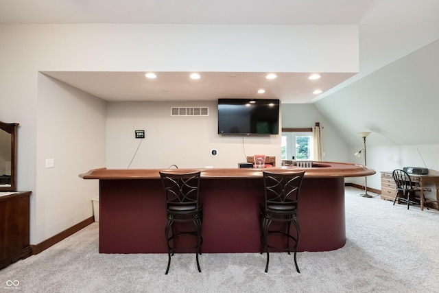 bar featuring light carpet and vaulted ceiling