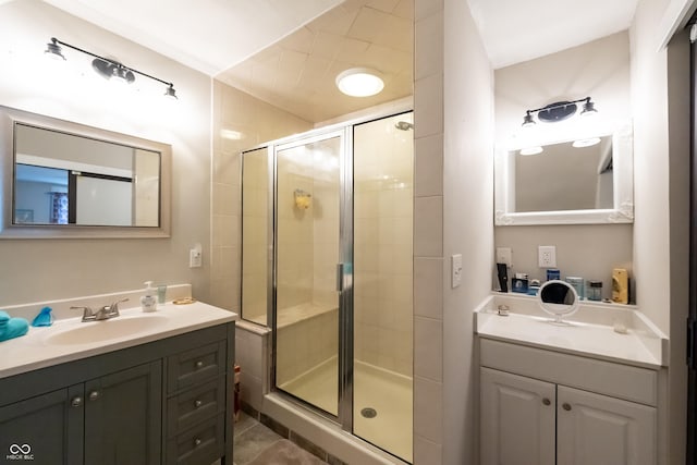 bathroom with a shower with door, vanity, and tile patterned flooring