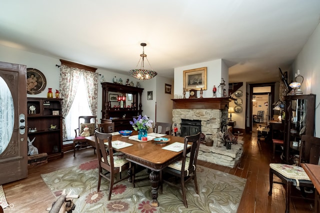 dining area with dark hardwood / wood-style flooring and a fireplace