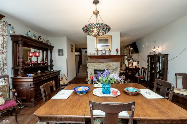 dining space with a fireplace and wood-type flooring