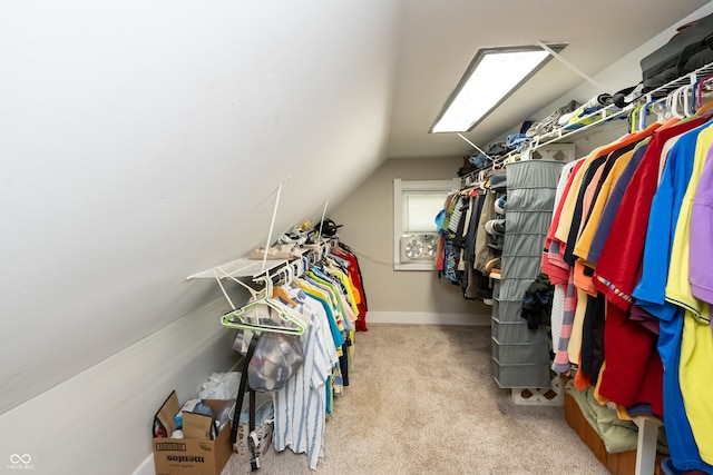 spacious closet featuring light colored carpet and vaulted ceiling