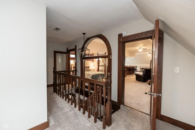 corridor with carpet and vaulted ceiling