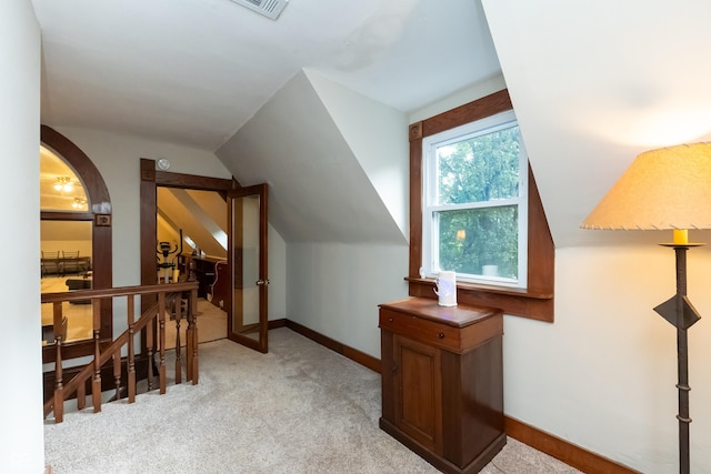 bonus room with light colored carpet and lofted ceiling