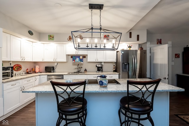 kitchen with a kitchen island, sink, white cabinetry, and stainless steel appliances