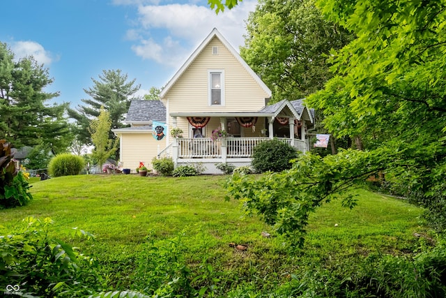 back of house with covered porch and a lawn