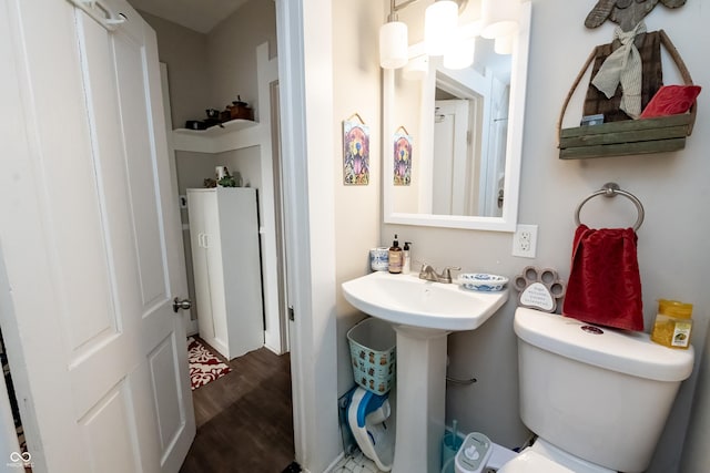 bathroom with hardwood / wood-style flooring, toilet, and sink