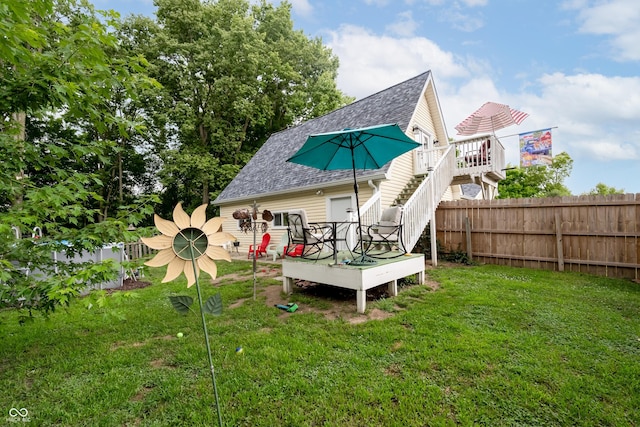 back of house featuring a lawn and a wooden deck