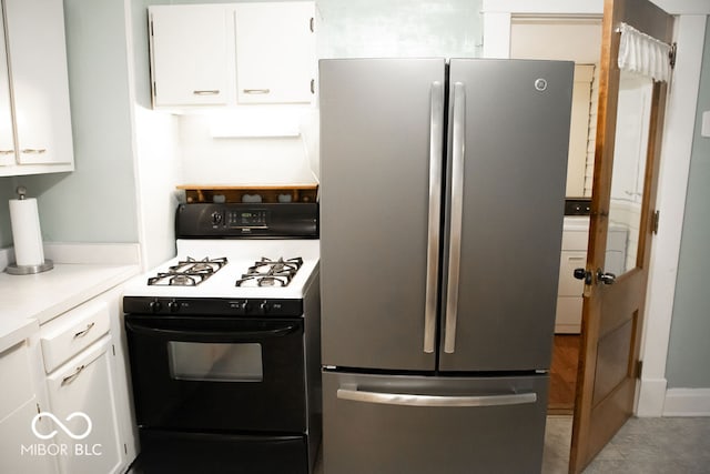 kitchen featuring tile patterned flooring, white cabinetry, white stove, and stainless steel refrigerator