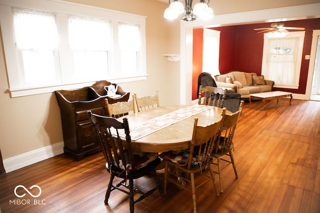 dining area featuring ceiling fan with notable chandelier and hardwood / wood-style flooring