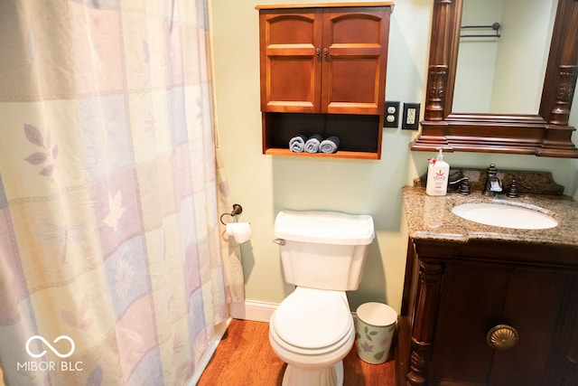 bathroom with toilet, vanity, and hardwood / wood-style flooring