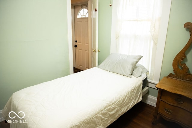 bedroom with dark hardwood / wood-style flooring