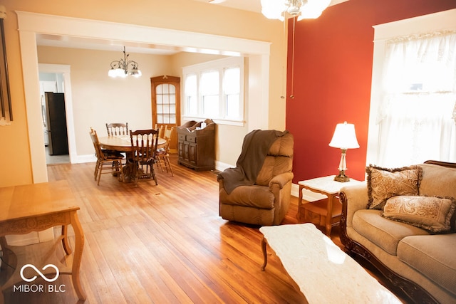 living room with hardwood / wood-style floors and a notable chandelier