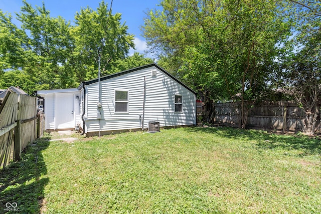 back of house featuring a yard and central AC unit