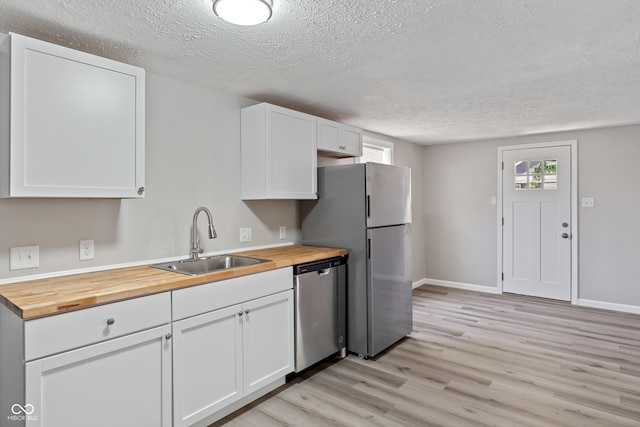 929 Olin Ave, Indianapolis, IN 46222 - kitchen featuring sink, wooden counters, stainless steel appliances, light hardwood / wood-style floors, and white cabinets