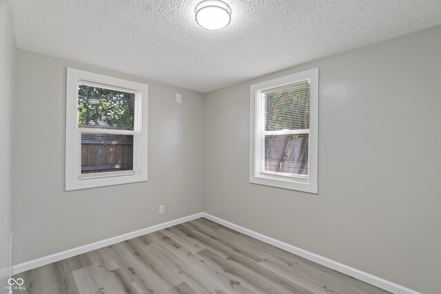 empty room featuring light hardwood / wood-style flooring and a textured ceiling