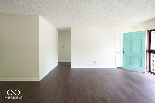 unfurnished room featuring a textured ceiling and dark hardwood / wood-style floors