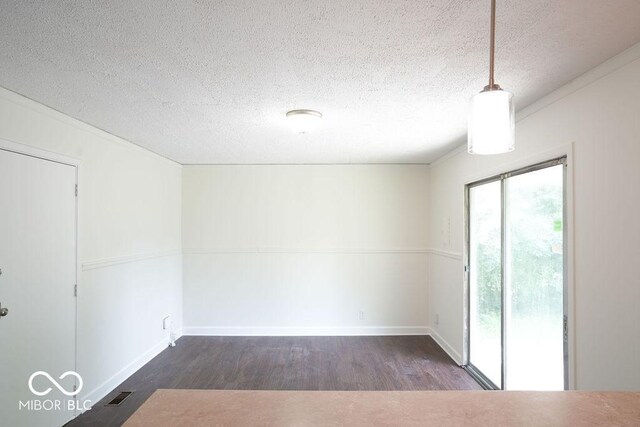 empty room featuring a textured ceiling and dark wood-type flooring