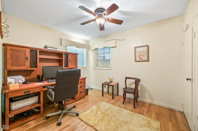 office with a textured ceiling, ceiling fan, and light wood-type flooring