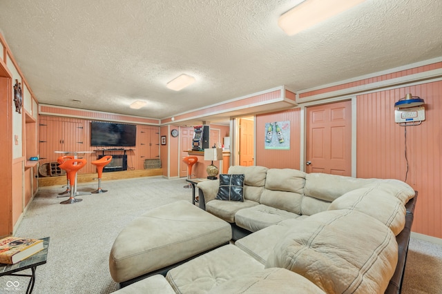 carpeted living room with wooden walls and a textured ceiling