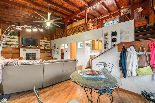 living room with beam ceiling, ceiling fan, wood ceiling, and light hardwood / wood-style floors