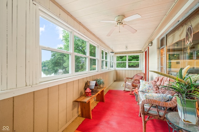 sunroom with ceiling fan, wooden ceiling, a healthy amount of sunlight, and a water view