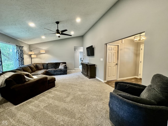 living room with a textured ceiling, carpet floors, and ceiling fan with notable chandelier