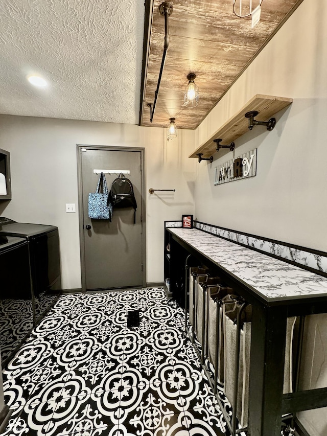 interior space featuring washer and clothes dryer, wooden ceiling, and a textured ceiling