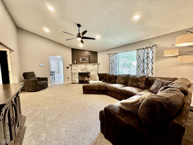 carpeted living room with a fireplace, a textured ceiling, vaulted ceiling, and ceiling fan