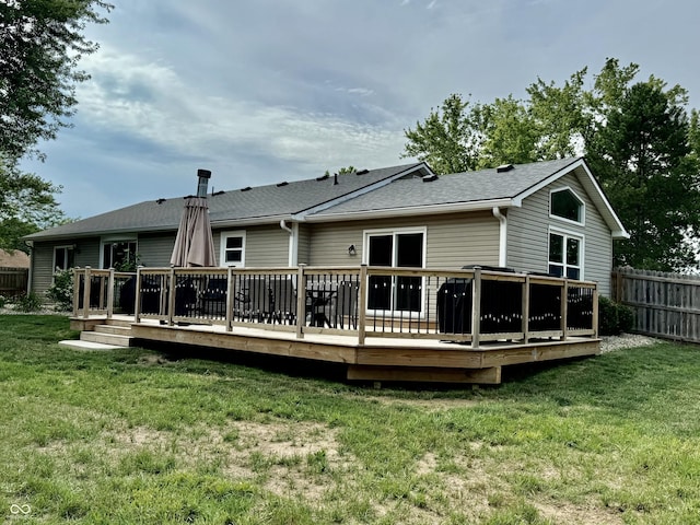 rear view of house with a lawn and a wooden deck