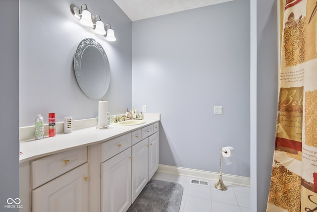 bathroom with vanity, a textured ceiling, and tile patterned flooring