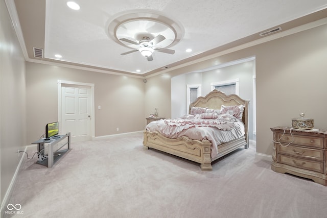 carpeted bedroom featuring a tray ceiling, crown molding, and ceiling fan