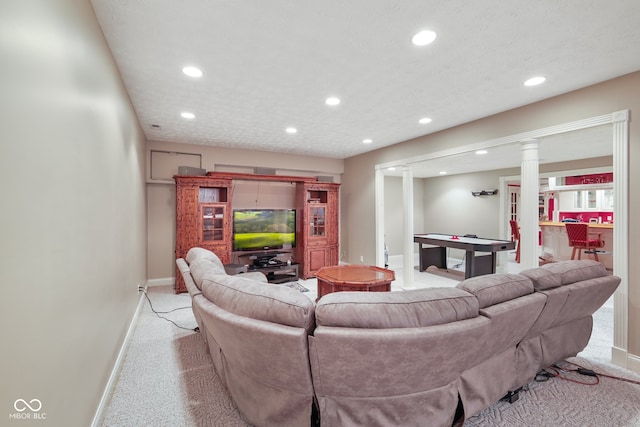 carpeted living room featuring decorative columns