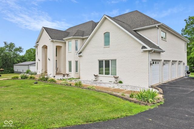 view of property with a garage and a front lawn