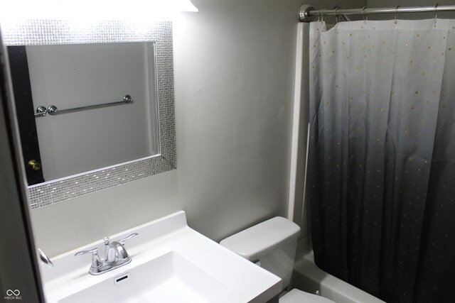 full bathroom with shower / tub combo with curtain, sink, and toilet