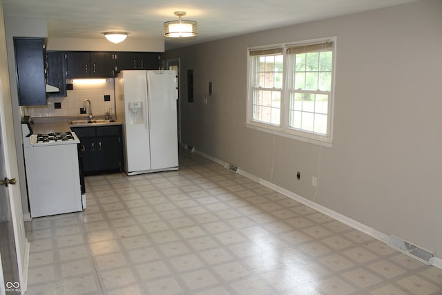 kitchen featuring tasteful backsplash, white appliances, extractor fan, sink, and light tile patterned floors