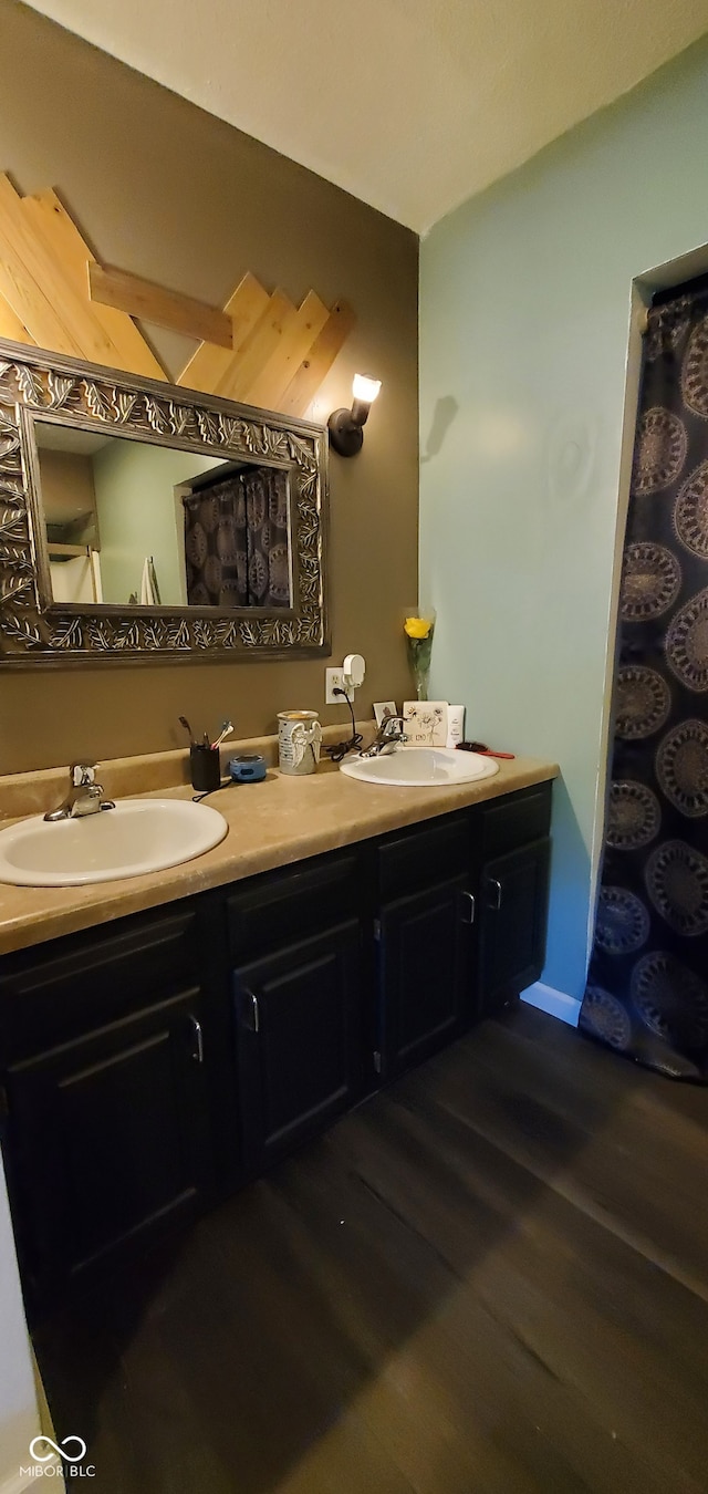 bathroom featuring double sink vanity and wood-type flooring