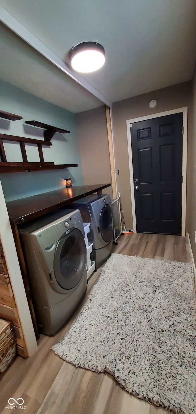 washroom with washer and dryer and hardwood / wood-style floors