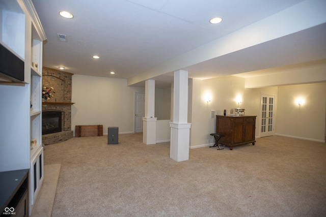 basement with a fireplace and light colored carpet