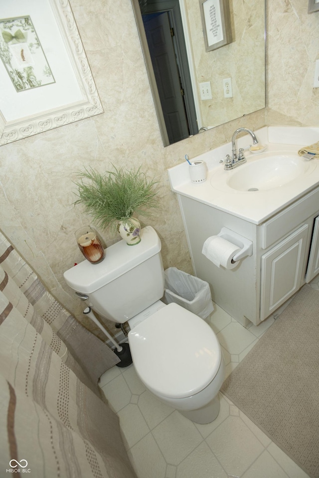 bathroom with toilet, vanity, and tile patterned floors