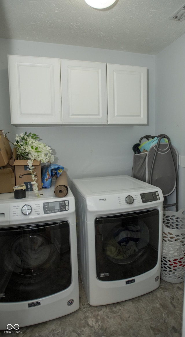 laundry room with washing machine and dryer and cabinets