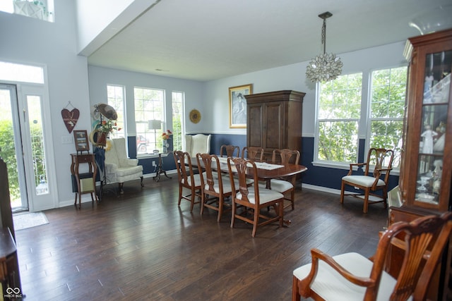 dining room with dark hardwood / wood-style flooring and a notable chandelier