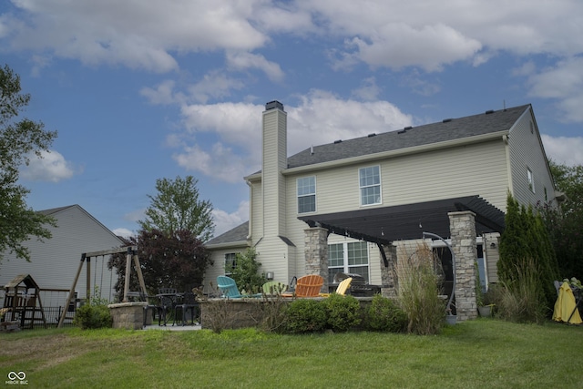 back of house featuring a yard, a playground, and a patio