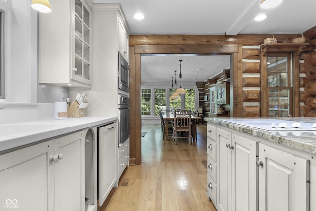 kitchen with rustic walls, white cabinets, and decorative light fixtures